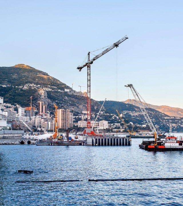 Working process near the Mediterranean sea coast in Monaco, buildings and hills on the background